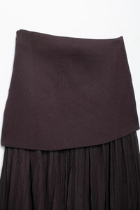 Detail showing asymmetric stitching of knit fabric and fine pleats in chocolate brown