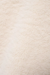 Close-up detail showing the soft texture and grain of beige Sherpa fleece fabric material