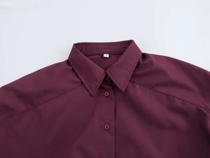 Detail view of burgundy shirt collar with precise stitching and size S label