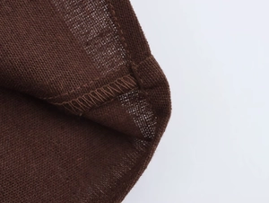 Dettaglio della cucitura professionale overlock e della trama del lino sui pantaloncini