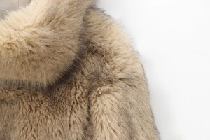 Macro detail of the dense faux fur collar with brown gradients and soft fibers