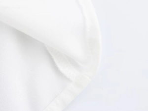 Dettaglio delle cuciture lisce e del tessuto in chiffon bianco sull'orlo della camicia