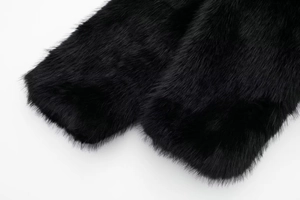 Close-up of the thick black faux fur texture and soft long plush material of the coat