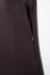 Macro shot of dark brown knit skirt featuring a hidden zipper and dense woven fabric