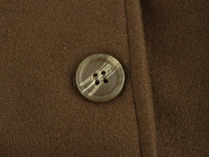 Macro view of marble textured button and thick brown wool fabric on the coat