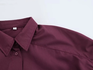 Detail of burgundy button-down shirt collar and raglan sleeve stitching with size label