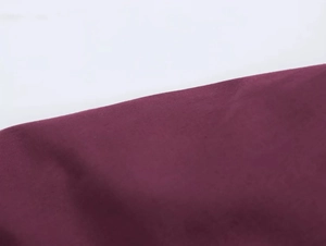 Detailed close-up showing the fine texture of dark red cotton blend fabric for women's shirt