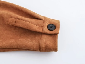 Detail of caramel suede cuff with a classic black button and precise stitching