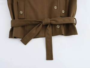 Detail of dark brown wool coat showing a tied waist belt and decorative resin buttons