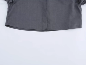 Dettaglio ravvicinato dell'orlo di camicia grigio scuro con cuciture rifinite e precise