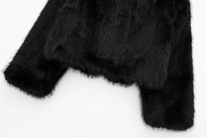 Detail of high-quality dense black faux fur texture on sleeve and hem of a winter coat