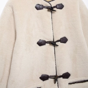 Cappotto in ecopelliccia crema da donna con chiusure a alamaro in pelle scura e rifiniture