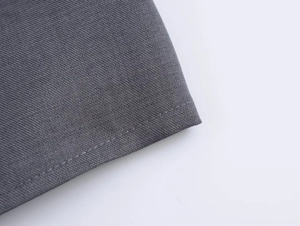 Macro di tessuto twill grigio scuro che mostra cuciture precise e texture densa