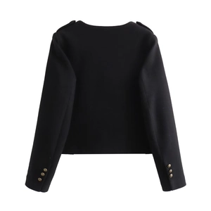 Detail of black fitted jacket featuring buttoned epaulettes and gold embossed cuffs