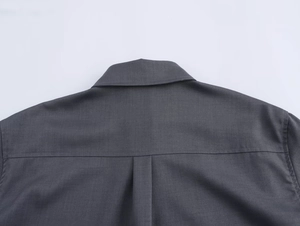 Dettaglio camicia grigio scuro con colletto a punta, sprone posteriore e piega piatta