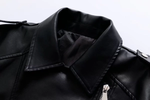 Detailed close-up of motorcycle jacket lapels with silver studs and epaulettes on black leather