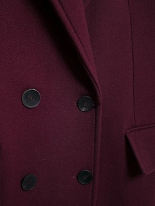 Macro shot of burgundy twill wool coat featuring matte black double-breasted buttons