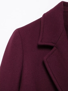 Close-up of wine red wool coat featuring notched lapel tailoring and twill texture