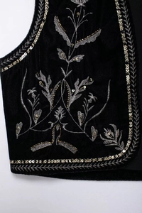 Ricamo dettagliato con fili floreali argentati e paillettes dorate su gilet in velluto nero