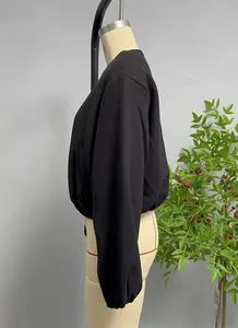 Détail de la texture de la veste bomber noire et de l'ourlet élastique sur mannequin