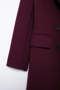 Close-up of deep purple wool blend coat showing refined pocket flap and black resin buttons