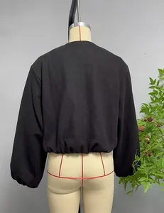 Détail de la veste aviateur courte noire avec ourlet et poignets élastiques sur mannequin