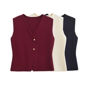Détail de gilets tricotés col V avec boutons dorés en bordeaux, crème et bleu marine