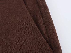Dettaglio macro del tessuto marrone scuro e cuciture precise della tasca sui pantaloncini
