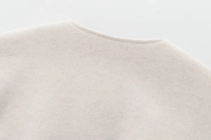 Détail de l'encolure ronde avec texture polaire dense sur veste aviateur beige