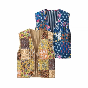 Close-up of V-neck quilted floral vests in blue and yellow patchwork with tie detail