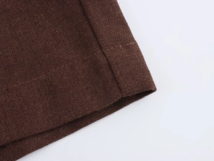 Dettaglio della trama del tessuto marrone caffè e cuciture dei pantaloncini casual a vita alta