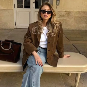 Detail view of a women's brown suede blazer with single-breasted buttons in urban street style