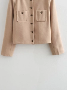 Detail of beige wool jacket fabric texture with flap pockets and vintage metal buttons