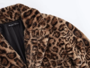 Détail du col d'un manteau en fausse fourrure léopard avec doublure noire et étiquette de marque