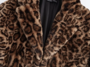 Gros plan sur la texture en fausse fourrure léopard et le large revers d'un manteau