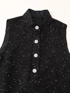 Détail du tissu en tweed avec sequins et boutons argentés en strass sur une veste noire
