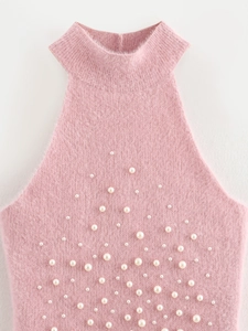 Dettaglio di un top a lupetto rosa in mohair con decorazioni di perle bianche e maglia