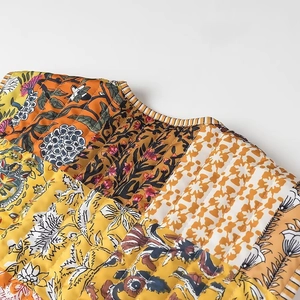 Detailed macro view of bohemian quilted floral fabric with intricate stitching on vest