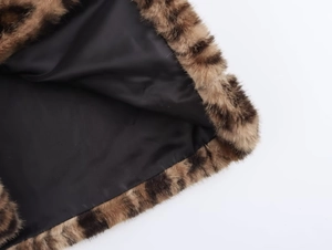 Vue macro du col en fausse fourrure léopard et détail de la doublure en satin noir