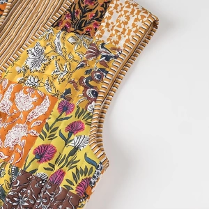Close-up of quilted patchwork vest showing floral patterns and striped binding details