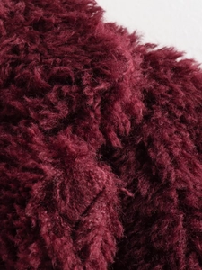 Makro-Detailaufnahme von burgunderrotem Kunstfell mit dicker und weicher Textur