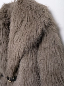 Luxurious brown faux fur coat for women with a black slim leather belt and gold buckle