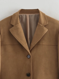 Detailed close-up of brown suede blazer featuring notched lapels and marble texture buttons