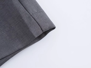 Vista macro dettagliata del tessuto twill grigio scuro con doppie cuciture precise