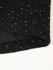 Détail du tweed noir avec paillettes argentées et texture métallique sur mini robe