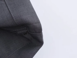 Dettaglio ravvicinato del tessuto twill grigio scuro e delle cuciture di rinforzo