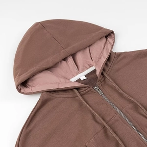 Dettaglio felpa con cappuccio marrone scuro con tessuto in cotone pesante e zip in metallo