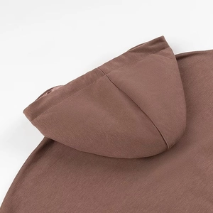 Dettaglio ravvicinato del cappuccio marrone con coulisse e trama in maglia a coste
