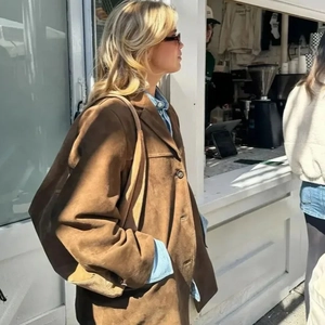 Women's brown suede jacket with classic lapels and buttons in a street style look
