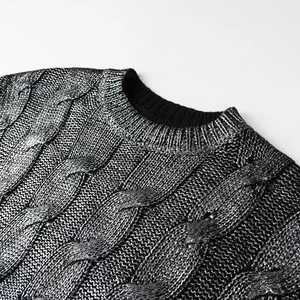 Detail of silver metallic cable-knit sweater featuring textured weave and ribbed crew neck